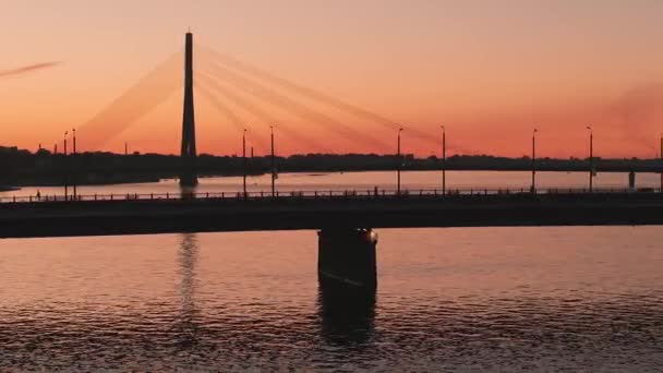 拉托维亚首都里加市美丽的空中景观 里加悬索桥上神奇的落日 公共交通工具经过大桥 — 图库视频影像