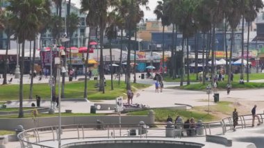 Venedik sahilindeki kaykay parkının günbatımında, Kaliforniya, ABD. Güzel Venedik plajı havası. Los Angeles 'ta insanlar paten yapıyor..