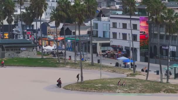 美丽的威尼斯海滩区在洛杉矶 从空中俯瞰威尼斯海滩 人们在那里冲浪 在海滩上漫步 走进不同的商店和酒吧 — 图库视频影像