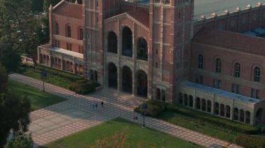 UCLA kampüsünün havadan görünüşü altın ışıkla yıkandı, Roma Uyanışı ve yemyeşil ortamda Gotik mimari sergilenirken, Royce Hall merkezde sergilendi..