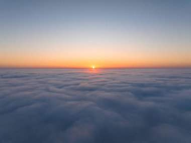 Bulutların üzerinde gün batımı. Gün batımında bulutların havadan görünüşü.