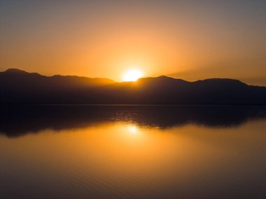 Kaliforniya 'daki Salton Denizi üzerinde hava manzarası. Gün batımında çölün ortasında kocaman bir göl..