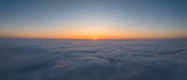 Sunset over the clouds. Aerial view of the clouds with the sunset.