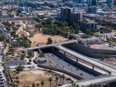 Phoenix, ABD 'deki otoyol ve kavşakların hava görüntüsü. Güneşli bir günde ABD metropolündeki yükseltilmiş yol ve trafik kavşaklarının insansız hava aracı görüntüsü.