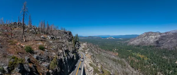 Mountain road in California through the forest leading to the Tahoe lake.