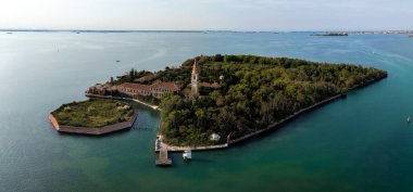 Venedik lagünündeki Poveglia 'nın hastalıklı hayalet adasının havadan görünüşü, Malamocco' nun karşısında Venedik, İtalya yakınlarındaki Canal Orfano Kanalı boyunca.