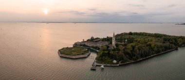 Venedik lagünündeki Poveglia 'nın hastalıklı hayalet adasının havadan görünüşü, Malamocco' nun karşısında Venedik, İtalya yakınlarındaki Canal Orfano Kanalı boyunca.