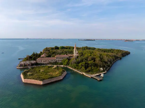 Venedik lagünündeki Poveglia 'nın hastalıklı hayalet adasının havadan görünüşü, Malamocco' nun karşısında Venedik, İtalya yakınlarındaki Canal Orfano Kanalı boyunca.