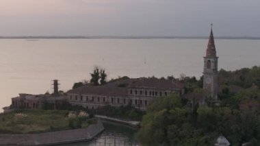 Venedik lagünündeki Poveglia 'nın hastalıklı hayalet adasının havadan görünüşü, Malamocco' nun karşısında Venedik, İtalya yakınlarındaki Canal Orfano Kanalı boyunca.