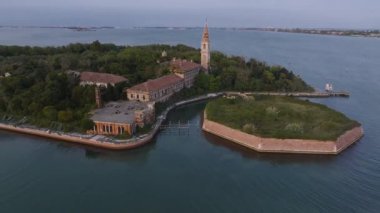 Venedik lagünündeki Poveglia 'nın hastalıklı hayalet adasının havadan görünüşü, Malamocco' nun karşısında Venedik, İtalya yakınlarındaki Canal Orfano Kanalı boyunca.