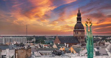 Özgürlük heykelinin yanında Riga 'nın üzerinde güzel bir gün doğumu manzarası var Letonya' da Milda. Özgürlük Anıtı.