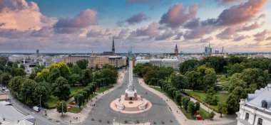 Özgürlük heykelinin yanında Riga 'nın üzerinde güzel bir gün doğumu manzarası var Letonya' da Milda. Özgürlük Anıtı.