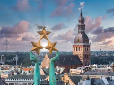 Özgürlük heykelinin yanında Riga 'nın üzerinde güzel bir gün doğumu manzarası var Letonya' da Milda. Özgürlük Anıtı.