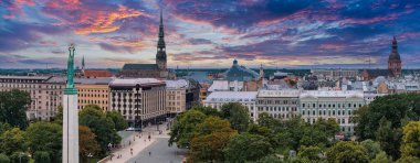 Özgürlük heykelinin yanında Riga 'nın üzerinde güzel bir gün doğumu manzarası var Letonya' da Milda. Özgürlük Anıtı.