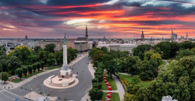 Özgürlük heykelinin yanında Riga 'nın üzerinde güzel bir gün doğumu manzarası var Letonya' da Milda. Özgürlük Anıtı.
