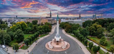 Özgürlük heykelinin yanında Riga 'nın üzerinde güzel bir gün doğumu manzarası var Letonya' da Milda. Özgürlük Anıtı.
