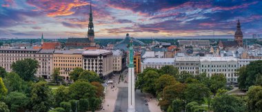 Özgürlük heykelinin yanında Riga 'nın üzerinde güzel bir gün doğumu manzarası var Letonya' da Milda. Özgürlük Anıtı.