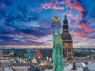 Özgürlük heykelinin yanında Riga 'nın üzerinde güzel bir gün doğumu manzarası var Letonya' da Milda. Özgürlük Anıtı.