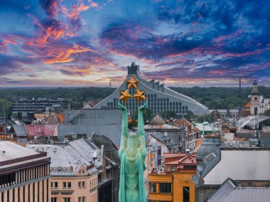 Özgürlük heykelinin yanında Riga 'nın üzerinde güzel bir gün doğumu manzarası var Letonya' da Milda. Özgürlük Anıtı.
