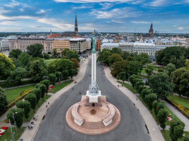 Özgürlük heykelinin yanında Riga 'nın üzerinde güzel bir gün doğumu manzarası var Letonya' da Milda. Özgürlük Anıtı.