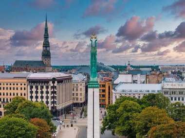 Özgürlük heykelinin yanında Riga 'nın üzerinde güzel bir gün doğumu manzarası var Letonya' da Milda. Özgürlük Anıtı.
