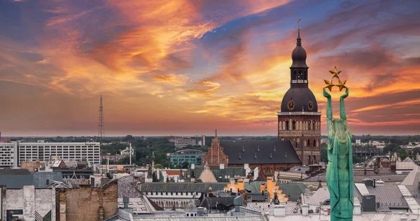 Özgürlük heykelinin yanında Riga 'nın üzerinde güzel bir gün doğumu manzarası var Letonya' da Milda. Özgürlük Anıtı.