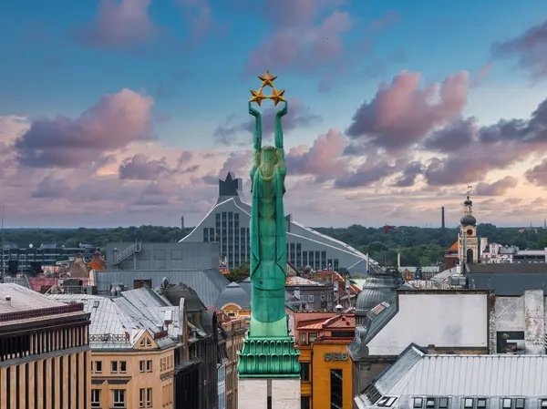 Özgürlük heykelinin yanında Riga 'nın üzerinde güzel bir gün doğumu manzarası var Letonya' da Milda. Özgürlük Anıtı.