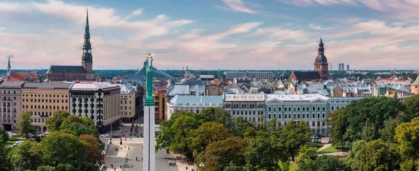 Özgürlük heykelinin yanında Riga 'nın üzerinde güzel bir gün doğumu manzarası var Letonya' da Milda. Özgürlük Anıtı.