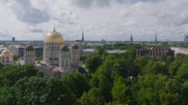 拉脱维亚里加基督大教堂的诞生 拜占庭风格的东正教大教堂 波罗的海区域最大的教堂 金色的圆顶 光滑的镀金圆顶在树林中闪烁着光芒 — 图库视频影像