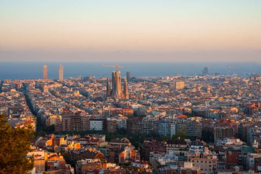 Barcelona 'nın gün doğumunda ya da batımında Sagrada Familia ve Torre Glories ve Hotel Arts gibi önde gelen gökdelenlerin yer aldığı altın ışıkla panoramik manzarası.