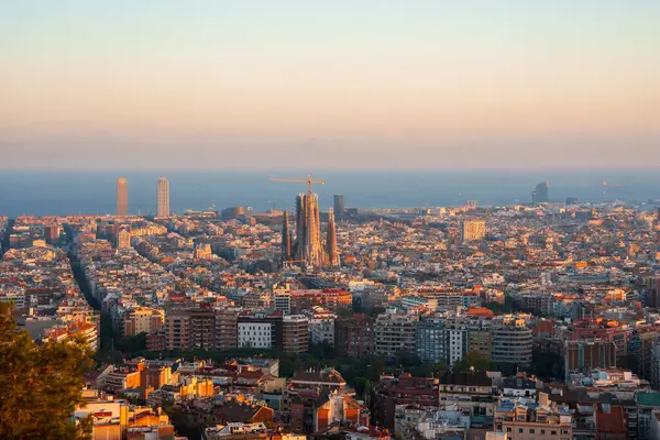 Barselona 'nın panoramik manzarası, Sagrada Familia' nın merkez sahnesiyle, Eixample semtleri şebeke sokakları ve modern ve tarihi mimarinin bir karışımı ile çevrili..