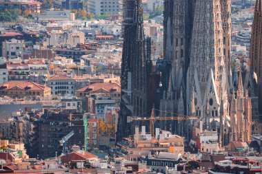Barcelonas ufuk çizgisine yakından bakın. Bitmemiş Bazilika de la Sagrada Familia, renkli konut ve ticari binalarla çevrili, yumuşak gökyüzü altında..