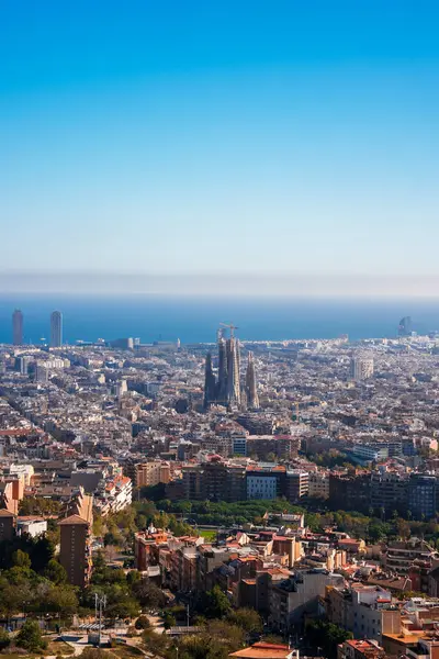 Açık mavi gökyüzü altında Sagrada Familia 'nın yer aldığı Barcelonas şehir manzarasının panoramik manzarası, Akdeniz ve modern mimarinin arka planda yer aldığı.