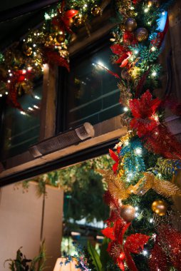 Londra 'da kırmızı ve altın kurdeleler, mücevherler ve parıldayan ışıklarla süslenmiş, geleneksel, samimi bir tatil atmosferi yaratan bir Noel çelengi..