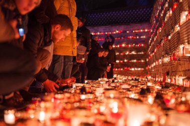 Gece basamaklarda mum yakan insanların saygı dolu bir araya toplanması birlik ve anma gösterisiyle, açık hava ortamında Letonya 'nın Bağımsızlık Günü' nü kutluyor gibi görünüyor..