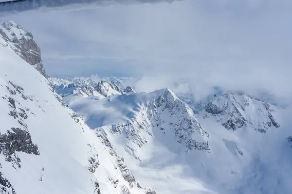 スイスのエンゲルベルクで穏やかな冬のシーンは 部分的に曇った空の下で険しく雪に覆われたピークで スキー愛好家に最適なダイナミックな影をキャスティングします — ストック写真