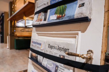 Engelberg 'de lüks bir otel lobisinde, siyah kayışlarla kaplanmış TagesAnzeiger gibi yerel ve uluslararası gazetelerin yer aldığı bir gazete standına yakın çekim..