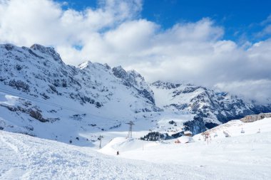 Kış sporları meraklıları, kar kaplı dağları, kayak kaldırışları ve çeşitli beceri seviyelerine sahip bir İsviçre Alpleri tatil beldesi olan Engelberg 'in yamaçlarından inerler..