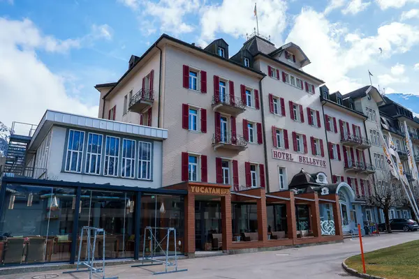 雅致的贝尔维尤酒店展示了欧洲古典建筑 在Engelberg有红色百叶窗 具有现代玻璃附属建筑和宁静的城市环境 — 图库照片