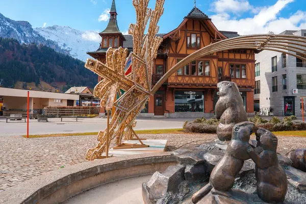 安格尔贝格镇广场 有青铜熊家族雕塑 现代雪花般的木制装置 传统的瑞士建筑 背景是威严的雪山 — 图库照片
