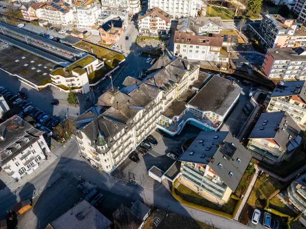 瑞士恩格尔伯格的空中景观 展示了一座白色立面的大酒店 五彩缤纷的休闲建筑 多样化的建筑 以及在晴朗天空下的火车站 — 图库照片