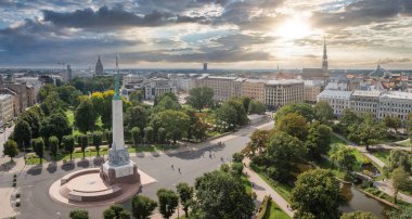 Özgürlük heykelinin yanında Riga 'nın üzerinde güzel bir gün doğumu manzarası var Letonya' da Milda. Özgürlük Anıtı.