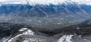 İsviçre, Verbier 'in hava manzarası sakin bir kış manzarası gösteriyor. Öndeki ağaçlar ve yamaçlar karla kaplanırken, kasaba İsviçre Alpleri ile çevrili bir vadide..