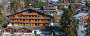 İsviçre 'deki Verbier kayak merkezinin hava panoramik manzarası. Dağların önünde duran klasik ahşap dağ evleri.. 