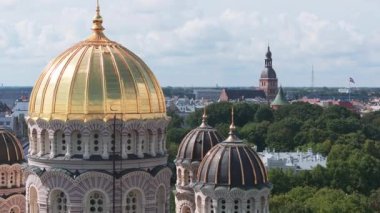 Riga, Letonya 'daki İsa' nın Doğumu Katedrali. Bizans tarzı Ortodoks katedrali, Baltık bölgesinin en büyüğü, altın renkli kubbesi, ağaçların arasında parıldayan yaldızlı kubbeleri var.
