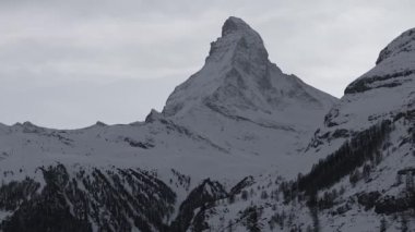 Güneşli bir günde, karlı Matterhorn zirvesinin manzarası. Mavi gökyüzü ve arka planda biraz bulut, İsviçre.