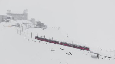 Zermatt, İsviçre - Gonergratbahn treni yoğun bir kar fırtınası sırasında Matterhorn 'u net bir şekilde gören ünlü turistik bölgedeki Gornergrat istasyonuna doğru koşuyor.. 