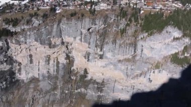 İsviçre 'deki Murren kayak merkezinin güzel panoramik hava manzarası. Uçurumun kenarındaki lüks oteller ve binalar.