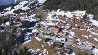 İsviçre 'deki Murren kayak merkezinin güzel panoramik hava manzarası. Uçurumun kenarındaki lüks oteller ve binalar.