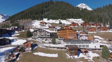 İsviçre 'deki Murren kayak merkezinin güzel panoramik hava manzarası. Uçurumun kenarındaki lüks oteller ve binalar.